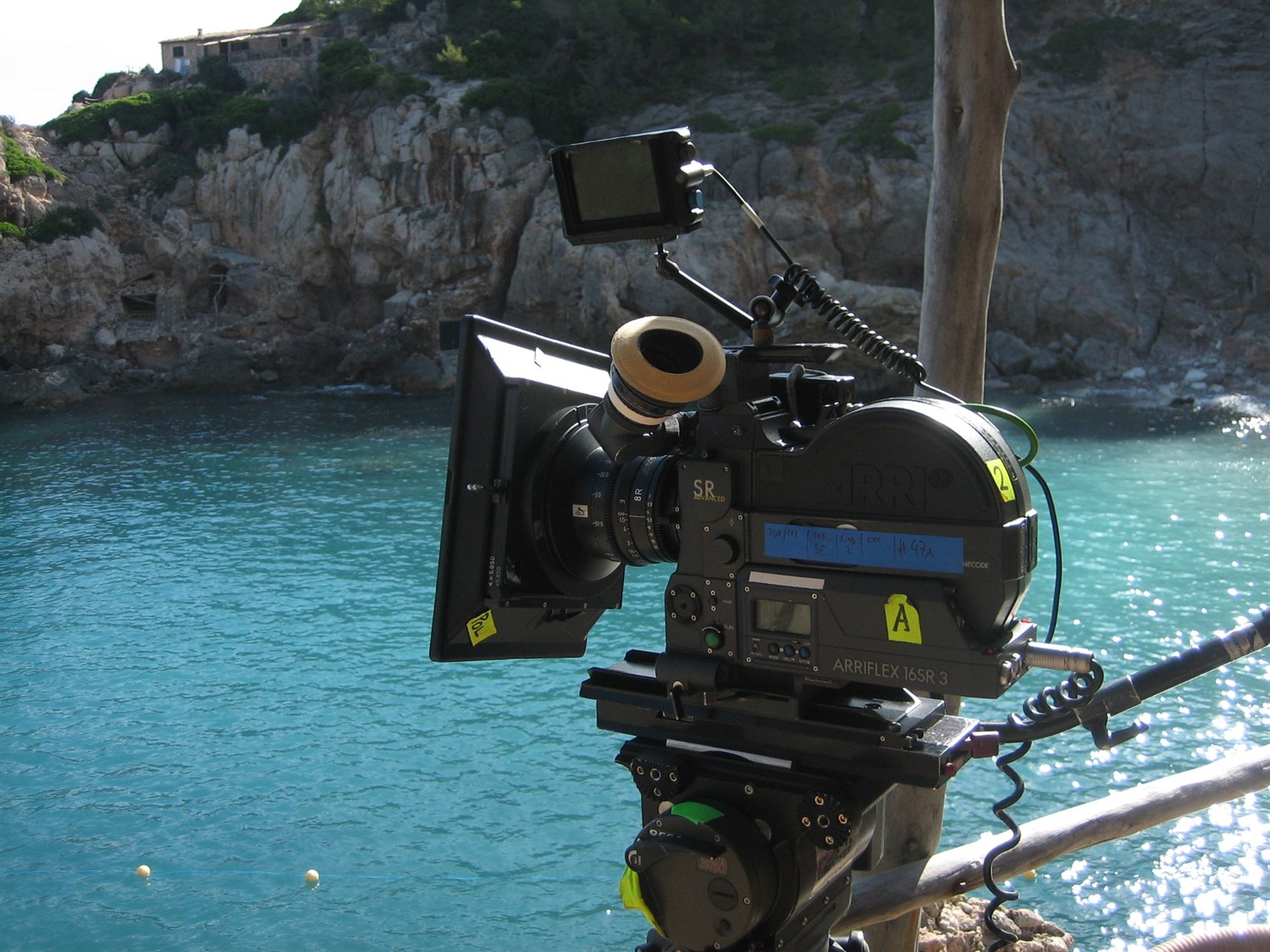 Film camera set up beside turquoise water
