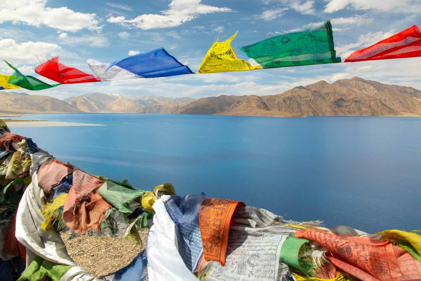 Colorful prayer flags above a high mountain lake