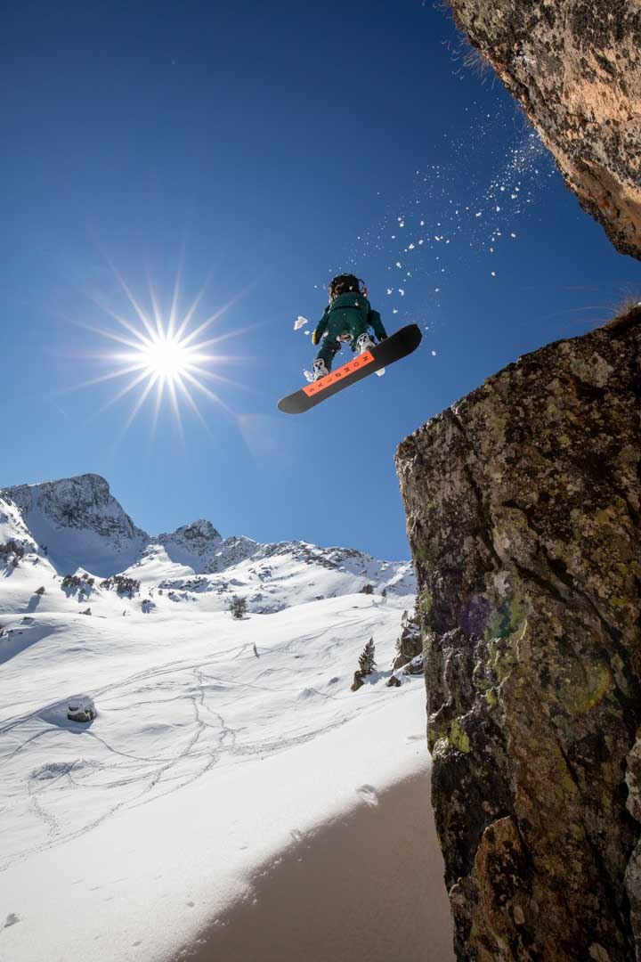 Snowboarder dropping between snow-covered rock walls