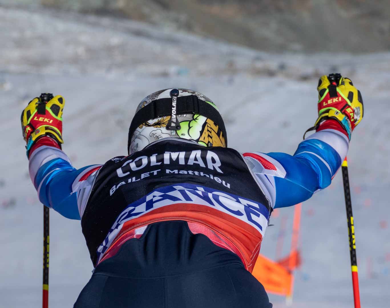 Downhill skier seen from behind on a snowy course