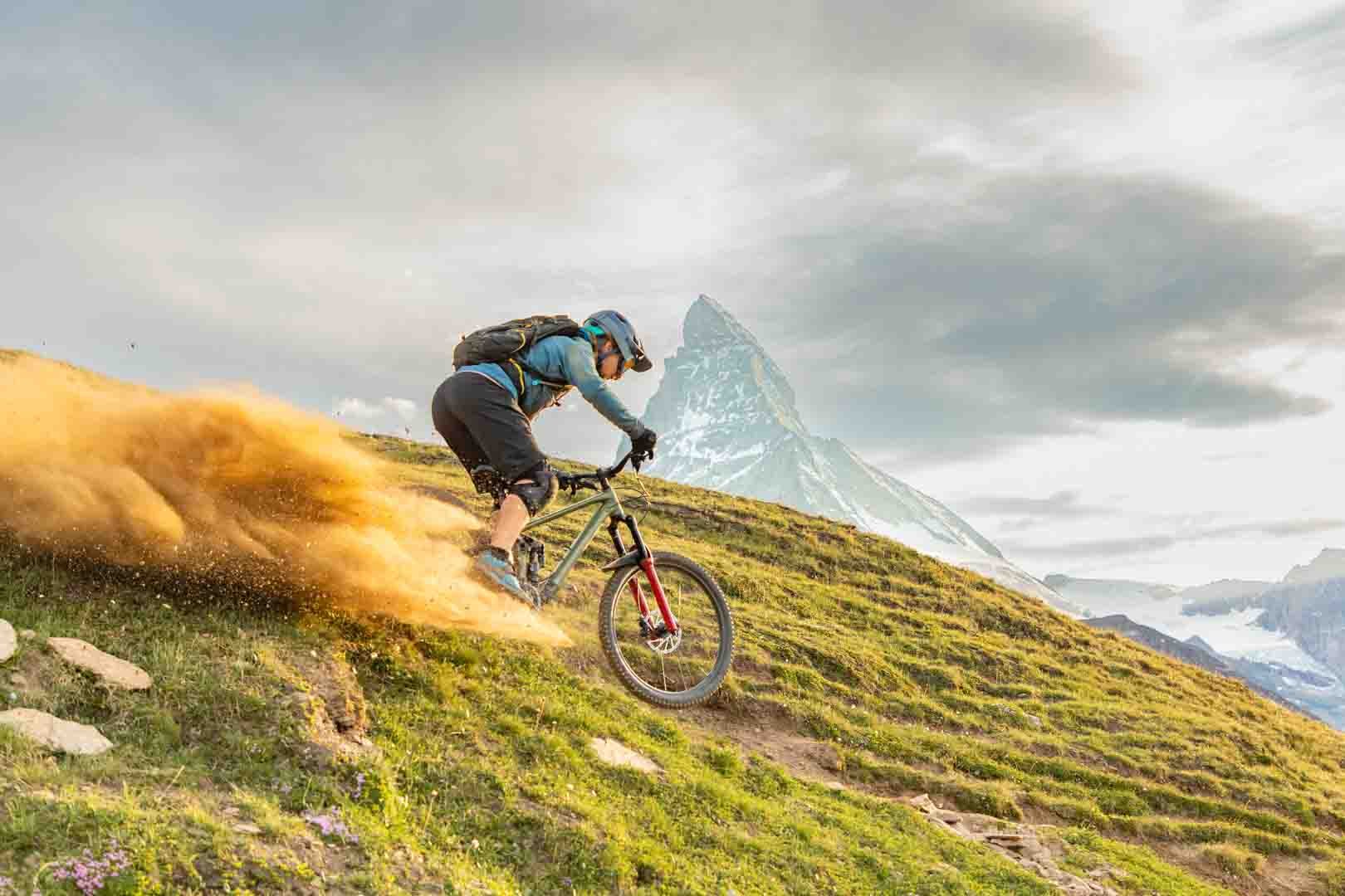 Enduro rider throwing dust on an alpine trail