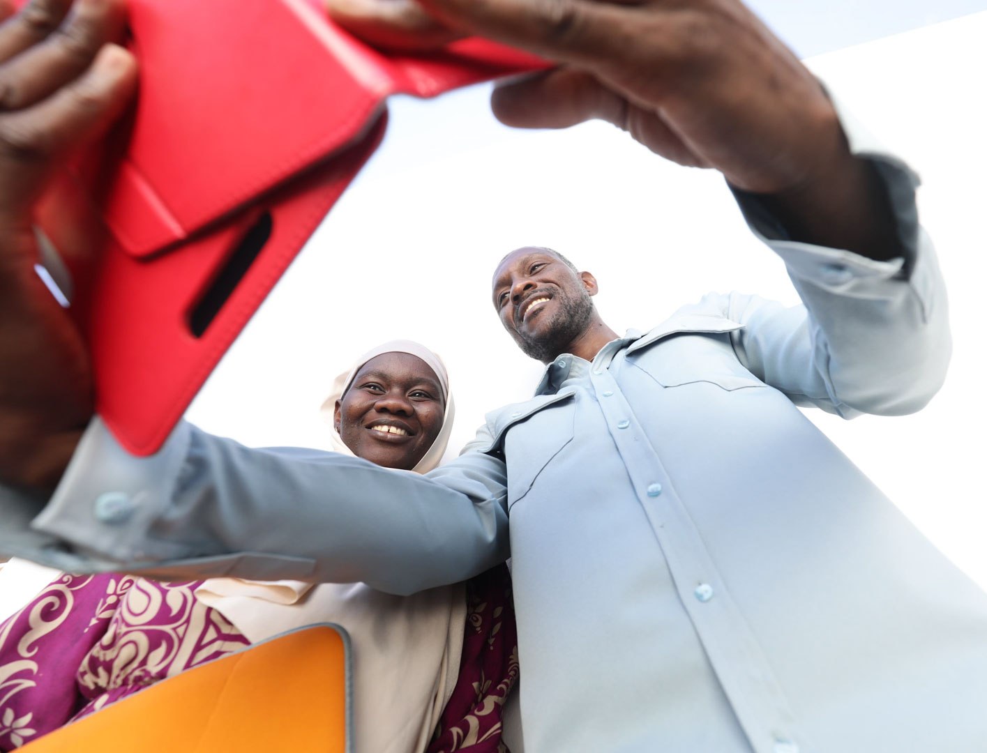 Two people smiling into a phone camera